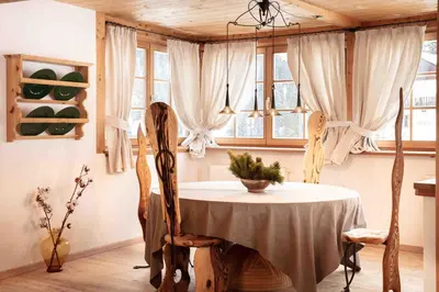 a dining room with a table and chairs and windows at CHALET D'ERT in La Valle