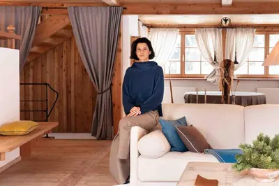 a woman sitting on a couch in a living room at CHALET D'ERT in La Valle