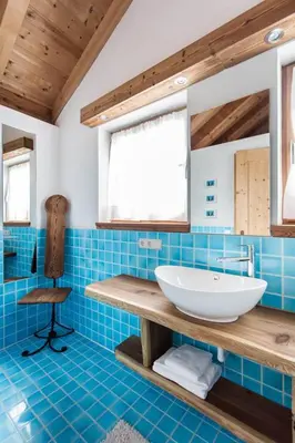 a bathroom with a white sink and blue tiles at CHALET D'ERT in La Valle