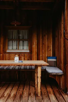 a wooden table and bench in a wooden room at CHALET D'ERT in La Valle