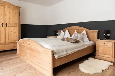 a bedroom with a wooden bed with pillows on it at CHALET D'ERT in La Valle