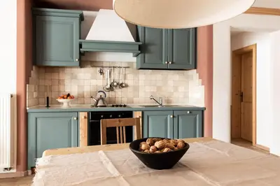 a kitchen with green cabinets and a bowl of food on a table at CHALET D'ERT in La Valle