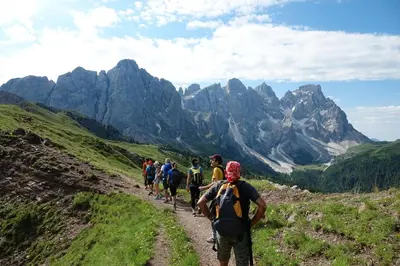 a group of people walking down a mountain trail at Berghotel Miramonti in Tesero