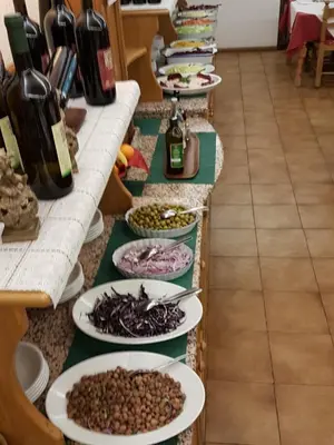 a buffet line with plates of food and bottles of wine at Hotel Villa Agomer in Canazei