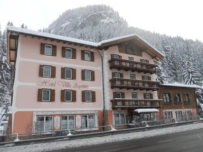 a building with a sign that reads lead with arrows at Hotel Villa Agomer in Canazei