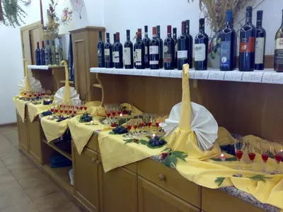 a row of tables with wine bottles and glasses at Hotel Villa Agomer in Canazei