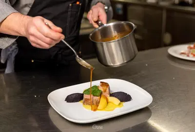 a person eating a plate of food on a counter at Family Hotel La Perla in Fiera di Primiero