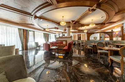 a restaurant with tables and chairs in a room at Family Hotel La Perla in Fiera di Primiero