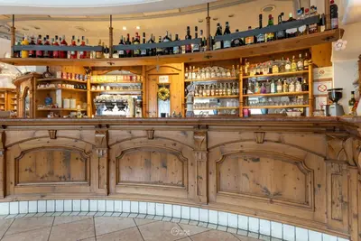 a bar with wooden cabinets and shelves at Family Hotel La Perla in Fiera di Primiero