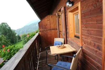 a wooden balcony with a table and chairs on it at Rasöller Hof in Villandro