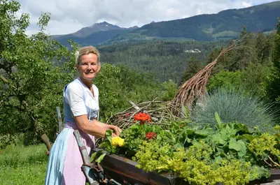 a woman standing next to a box of flowers at Falkenau in Chienes