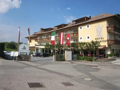 a hotel with flags in front of a building at Hotel Weingarten in Caldaro