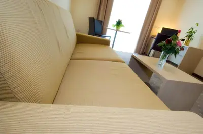 a hotel room with two beds and a vase of flowers at Hotel Weingarten in Caldaro