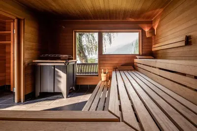 a sauna with a bench and a window at Parc Hotel Am See in Caldaro