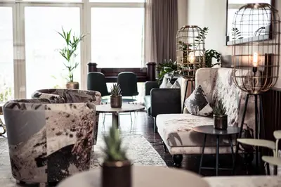a living room with couches and tables at Parc Hotel Am See in Caldaro