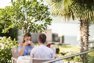 a man and a woman sitting at a table at Parc Hotel Am See in Caldaro