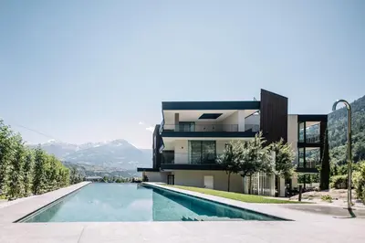 a house with a swimming pool in front of it at Garni-Hotel Der Forsterhof in Lagundo