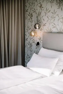 a bedroom with a bed with two white pillows at Garni-Hotel Der Forsterhof in Lagundo