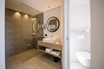 a bathroom with a sink and a mirror at Garni-Hotel Der Forsterhof in Lagundo