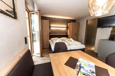 a hotel room with two beds and a table at Haus Bergfrieden Seiser Alm Bahn in Siusi