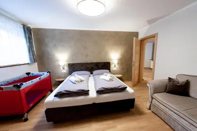a bedroom with a large bed and a couch at Haus Bergfrieden Seiser Alm Bahn in Siusi