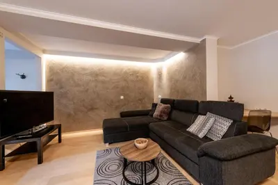 a living room with a couch and a tv at Haus Bergfrieden Seiser Alm Bahn in Siusi
