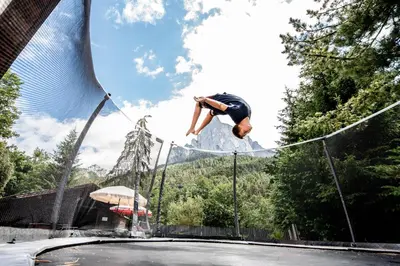 a man jumping over a rope on a trampoline at Haus Bergfrieden Seiser Alm Bahn in Siusi