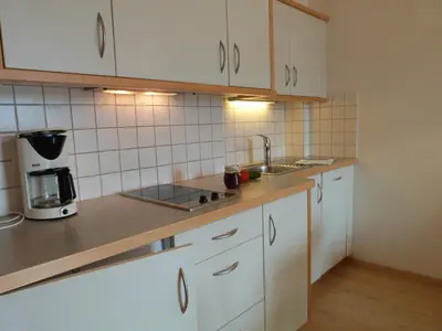 a kitchen with white cabinets and a sink at Garni Nunnemairhof in Schenna