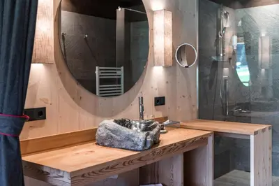 a bathroom with a sink and a mirror at Dolomites Living Hotel Tirler in Alpe di Siusi