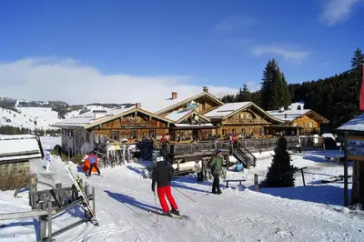 a group of people skiing in front of a ski lodge at Dolomites Living Hotel Tirler in Alpe di Siusi