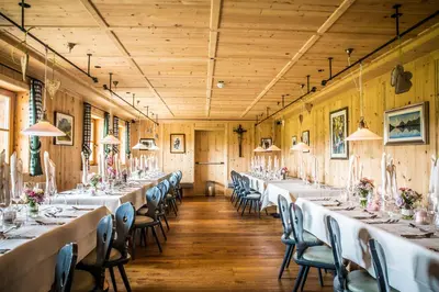 a row of tables in a room with wooden walls at Dolomites Living Hotel Tirler in Alpe di Siusi