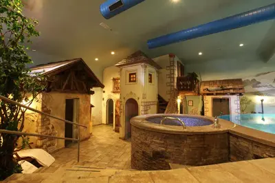 a large bathroom with a tub in the middle of a pool at Hotel La Perla Wellness & Beauty in Canazei