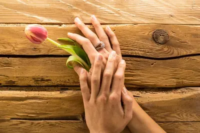a person with their hands on a table with a flower at Hotel La Perla Wellness & Beauty in Canazei