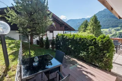 a patio with a table and chairs on a deck at Garni Alba Bed & Breakfast in Ortisei