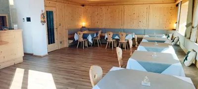 a restaurant with tables and chairs in a room at Garni Alba Bed & Breakfast in Ortisei