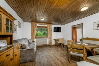 a living room with a couch and a table at Cësa Panaval Apartments in Santa Cristina in Val Gardena
