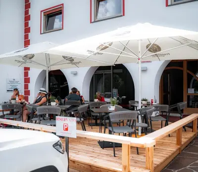 a restaurant with people sitting at tables under umbrellas at Cësa Panaval Apartments in Santa Cristina in Val Gardena