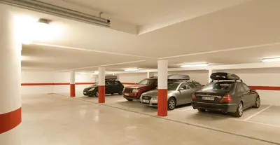 a parking garage with several cars parked in it at Cësa Panaval Apartments in Santa Cristina in Val Gardena