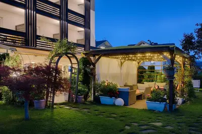 a gazebo with lights and plants in a yard at Hotel Kristall in Falzes
