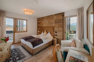 a bedroom with a bed and a couch in a room at Hotel Kristall in Falzes
