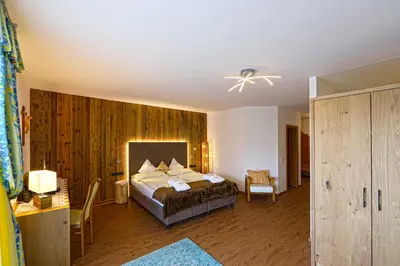 a bedroom with a bed in a room with wooden walls at Hotel Kristall in Falzes