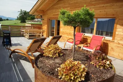 a patio with chairs and a tree in a planter at Chalet Frieda in Mühlbach