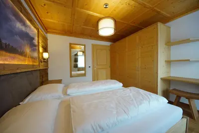 a bedroom with two beds in a room with wooden ceilings at Agriturismo Grones in San Martino in Badia