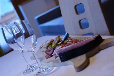 two wine glasses and a sandwich on a table at Agriturismo Grones in San Martino in Badia