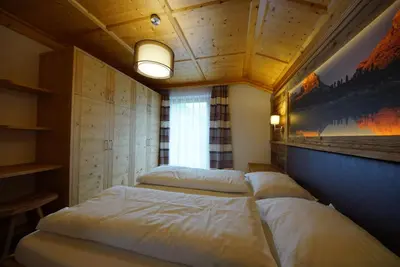a bedroom with two beds and a painting on the wall at Agriturismo Grones in San Martino in Badia