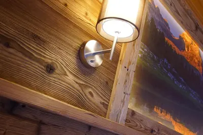 a light on a wooden wall with a lamp on it at Agriturismo Grones in San Martino in Badia