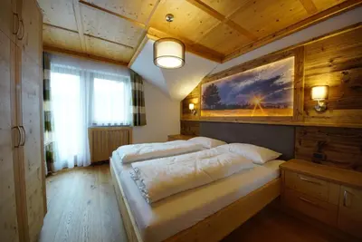 a bedroom with a large bed with a painting on the wall at Agriturismo Grones in San Martino in Badia