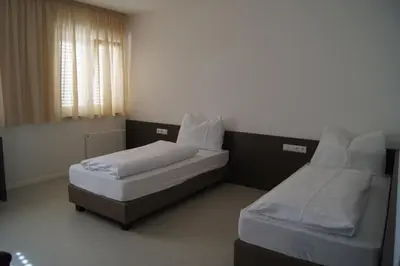 a bedroom with two beds and a window at Pension Lichtenburg in Nalles