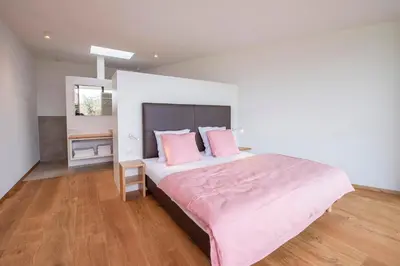 a bedroom with a large bed with pink pillows at La Vinea in Caldaro