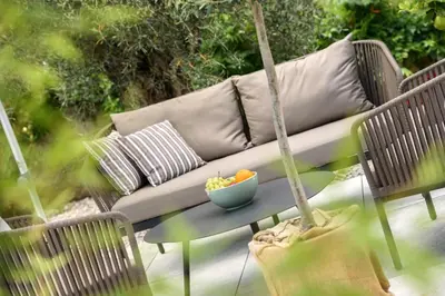 a hammock with a couch and a bowl of fruit on a table at La Vinea in Caldaro
